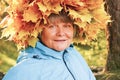 A woman with a wreath of yellow maple leaves on her head