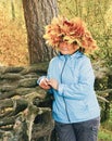 A woman with a wreath of yellow maple leaves on her head