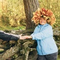 A woman with a wreath of yellow maple leaves on her head