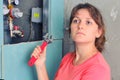 A woman with a wrench in her hand pondered next to the water pipes, close-up. Repair of sewer apartment, installation and