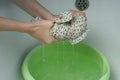 A woman wrings out a hand-washed dress over a basin, closeup view. Royalty Free Stock Photo