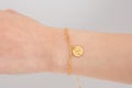 Woman wrist wearing golden butterfly bracelet set against a white background. Beautiful valentine's gift Royalty Free Stock Photo