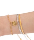 Woman wrist wearing golden butterfly and snake chain bracelets set against a white background. Beautiful valentine's gift Royalty Free Stock Photo