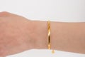 Woman wrist wearing golden snake chain bracelet set against a white background. Beautiful valentine's gift Royalty Free Stock Photo