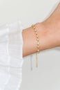 Woman wrist wearing golden zircon sparkle bracelet set against a white background Royalty Free Stock Photo