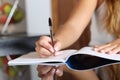 Woman writer hand writing in a notebook at home