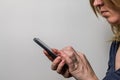 Woman writes a message on her smartphone on light background Royalty Free Stock Photo