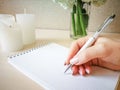 A woman writes in a notebook with a beautiful pen. Royalty Free Stock Photo