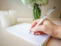 A woman writes in a notebook with a beautiful pen. Royalty Free Stock Photo