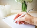 A woman writes in a notebook with a beautiful pen. Royalty Free Stock Photo