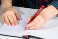 Woman writes in a notebook and holds pen with her left hand. The girl works in the office. Left-handers Day August 13th