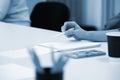 woman writes in a notebook at a meeting of colleagues in the corporate boardroom