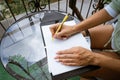 woman writes in a notebook at a table on the terrace Royalty Free Stock Photo