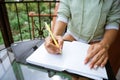 woman writes in a notebook at a table on the terrace Royalty Free Stock Photo