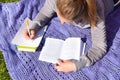 A woman writes out important notes from a textbook. student is preparing for a difficult exam in the summer. Royalty Free Stock Photo