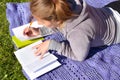A woman writes out important notes from a textbook. student is preparing for a difficult exam in the summer. Royalty Free Stock Photo
