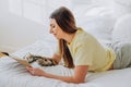 Woman writes in paper notebook with bionic arm lying on bed Royalty Free Stock Photo