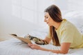 Woman writes in paper notebook with bionic arm lying on bed Royalty Free Stock Photo