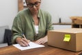 woman writes a return order at home, fills out the form to return a purchased item.