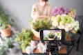 A woman writes a video blog or online course. Flower school concept. Florist woman creates flower arrangement in a
