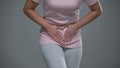 Woman writhing from pain in lower abdomen, menstrual pain, risk of miscarriage