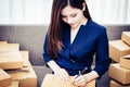 Woman writing address package for online business Royalty Free Stock Photo