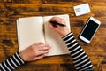 Woman writing contact list from phone into business agenda Royalty Free Stock Photo