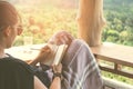 Woman is writing down in small white memo notebook for take a note plan to do or write a book with beautiful terrace of house and