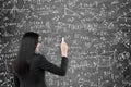 Woman writing formulas on blackboard