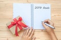 Woman writing 2019 Goals word with notebook and Christmas decoration on wooden table, Top view and copy space. Happy New Year New Royalty Free Stock Photo