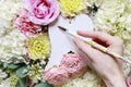 Woman writing greetings on white angel`s wings. Romantic flower ornament Royalty Free Stock Photo