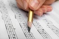 Woman writing music notes on sheet with pencil Royalty Free Stock Photo