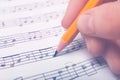 Woman writing music notes on sheet with pencil Royalty Free Stock Photo