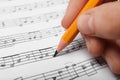 Woman writing music notes on sheet with pencil Royalty Free Stock Photo