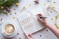 Woman writing in notebook goals plans wish list for new year 2020, flat lay Royalty Free Stock Photo