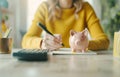 A woman is writing in a notebook with a piggy bank on the table by AI generated image Royalty Free Stock Photo