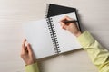 Woman writing in notebook at white wooden table, top view Royalty Free Stock Photo