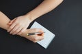 Woman writing in notepad at black table Royalty Free Stock Photo