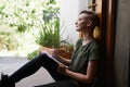 Woman, writing notes and thinking on floor in home for brainstorming, reflection and serious by garden. Dream, notepad Royalty Free Stock Photo