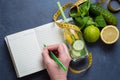 Woman writing nutrition plan diet menu and fitness workout routine. Healthy detox water Royalty Free Stock Photo