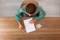 Woman writing on sheet of paper at table indoors Royalty Free Stock Photo