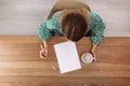 Woman writing on sheet of paper at table indoors Royalty Free Stock Photo