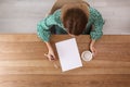 Woman writing on sheet of paper at table indoors Royalty Free Stock Photo