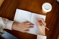 A woman writing something in a book at a table in a cafe. top view image Royalty Free Stock Photo