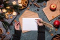 Woman writng a Christmas letter with gold pen. Royalty Free Stock Photo