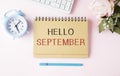 woman written hello september text on notepad with keyboard