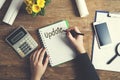 Woman written Update text on notepad with stationary on table Royalty Free Stock Photo