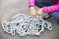 Woman's arms trying to raise a heavy metallic chain