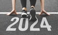 Woman& x27;s feet ont the road, begin to run, fstart of New year 2024, planning, goal, and new year resolution. Royalty Free Stock Photo