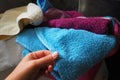 A woman& x27;s hand is feeling a cotton colored towel from a basket with dirty laundry. Laundry sorting and washing